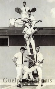 The velvetones including norm shaver  gerry lafontaine  lyle kreller  bert hamer and stu townsend. the group is posing on a ladder and roof of the a w building in guelph2
