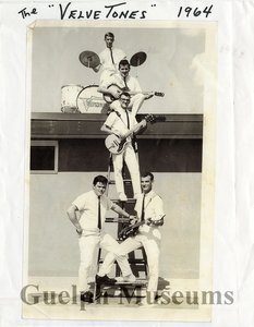 The velvetones including norm shaver  gerry lafontaine  lyle kreller  bert hamer and stu townsend. the group is posing on a ladder and roof of the a w building in guelph.