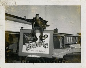Norm shaver sitting on top of a velvetones sign. 